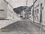 Calle Bolívar de Guarenas, década de 1950. Al fondo se observan camiones usando la calle en sentido sur para ascender longitudinalmente el Pueblo Arriba. Se observa la esquina de la calle Colón y la casa donde funcionó el antiguo hospital de Guarenas, el cual se inhabilitó después del terremoto del 29 de julio de 1967. La calle Bolívar se considera la calle prima de Guarenas.
