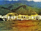 Panorámica de la Urbanización 27 de Febrero (antes Menca de Leoni), Guarenas, año 1979. Vista desde la Urb. Oropeza Castillo, en el terreno donde hoy está la Cancha de Futbol Javier "Manito" Rivas. Se aprecia el Centro Comercial Miranda y el Samán. Aún no existía la Iglesia Sagrado Corazón de Jesús ni los bloques frente a esta Iglesia.