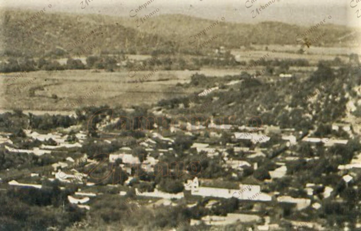 Al fondo y al centro, Carretera Nacional en la Guarenas del año 1915. Ésta conducía a la Hacienda Trapichito, en cuyos terrenos sería construido en 1959 el Grupo Escolar "Ambrosio Plaza". En la parte inferior se observa la Iglesia La Candelaria.