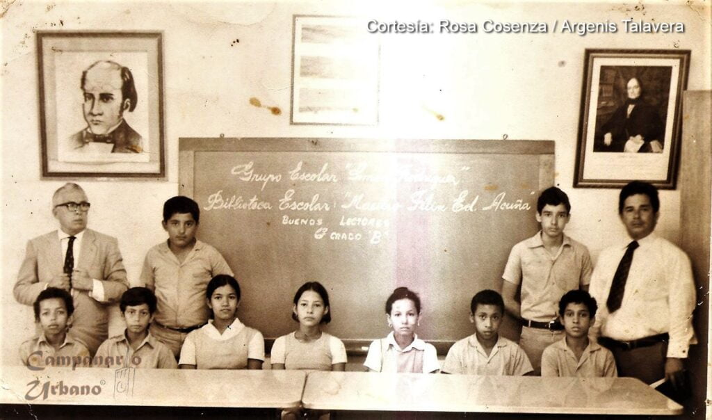 Propietario: Rosa Cosenza / Argenis Talavera. Lugar: Biblioteca Escolar "Maestro Félix Eduardo Acuña Ruiz", Escuela Estadal Concentrada "Simón Rodríguez", Guarenas, Edo. Miranda. Captura: Década de 1970. Comentario: Buenos Lectores del 6to. Grado "B". De izquierda a derecha, de pie: Profesor Mariano Espinoza (Bibliotecario), Raúl Fausto Carrero, Gilberto Carvallo, Profesor César de Jesús Peralta (Subdirector). De izquierda a derecha, sentados: Jesús Robles Linares, Rubén Antonio Milano López, Aimara Pérez, Flor María Fausto Carrero, Irene América Jiménez Parra, Ricardo Campos.