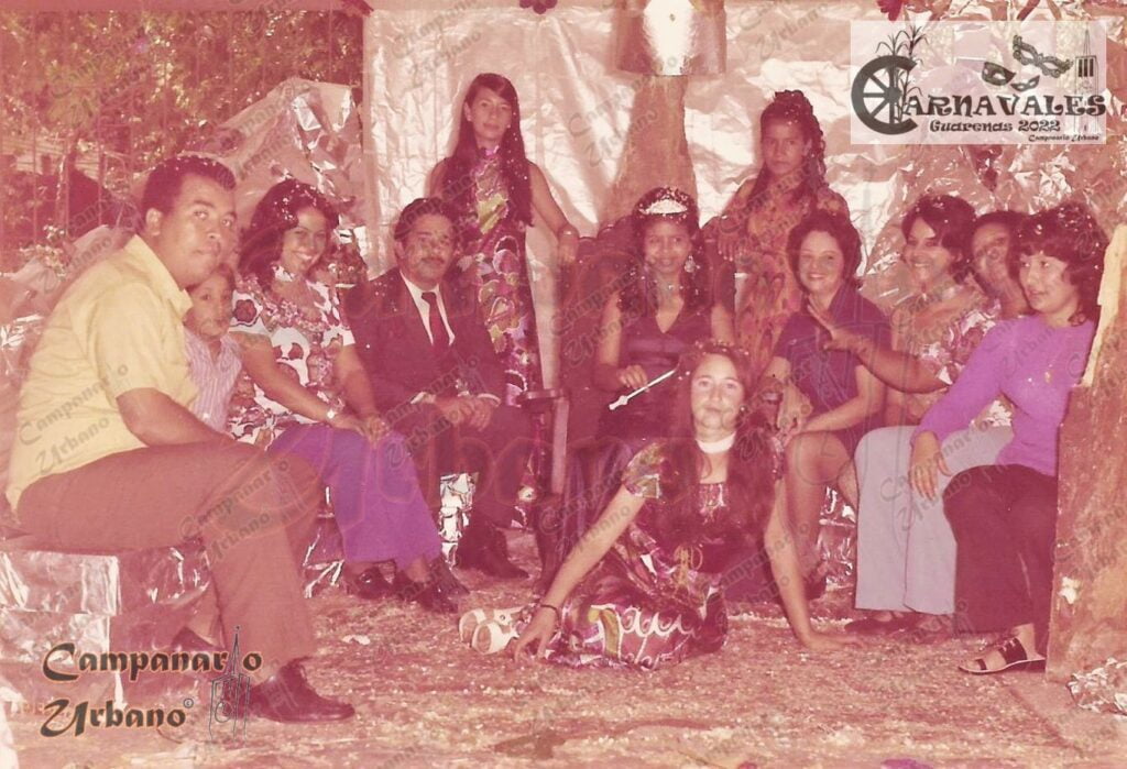Reina del Carnaval 1970 en su trono y junto a su Corte. Acompañadas de los docentes Pablo Muro, César Peralta, Janet de Carelli, Olga de Hernández, Rita de Leal y Fabiola Vera. Escuela Estadal Simón Rodríguez de Guarenas. Color original.