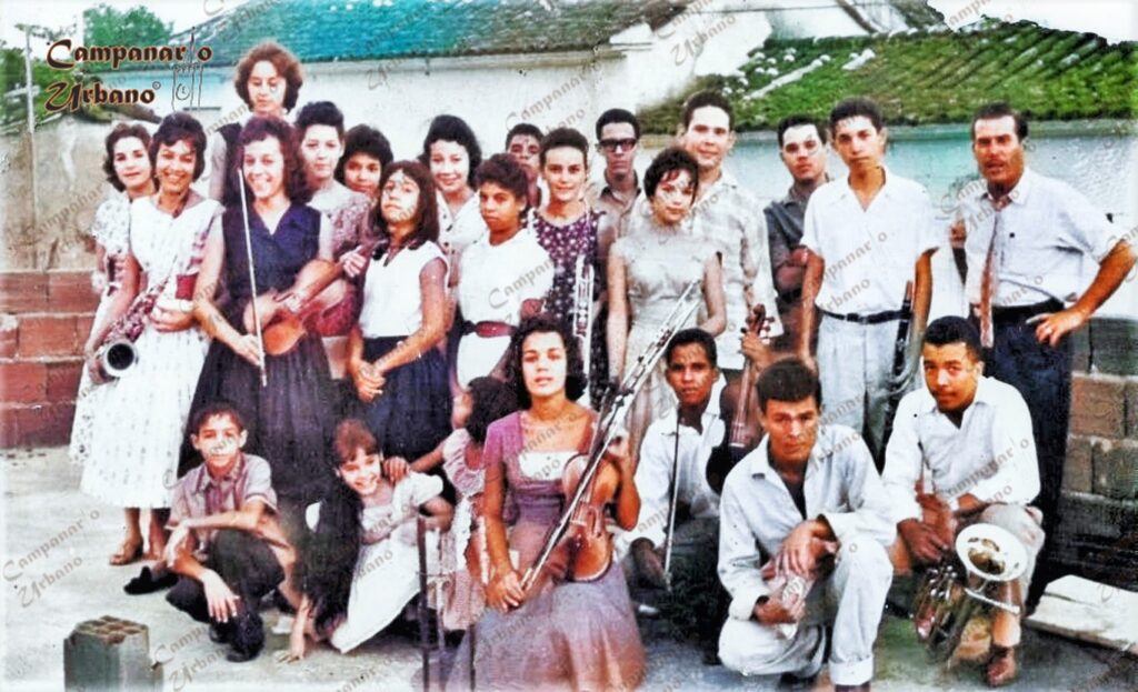 Escuela de Música Guarenas, año 1959. Fotografía coloreada digitalmente por Campanario Urbano. Estudiantes: Celsa y Nelly Cardozo, Gladys Hernández, Rosalba Morales, Carmen Alicia y Ana González, Miriam García, Neida Silva, Lida Castillo, Yolanda Mirabal, Dunia y Aquiles Toro, Iris León, Ramiro Ortega, Janeth García, Roberto Tovar, Antonio Castillo, Luis Caraballo, Humberto Robledo y Pablo Muro.